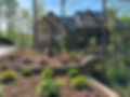 Large brick home with multi-level tiered landscaping.