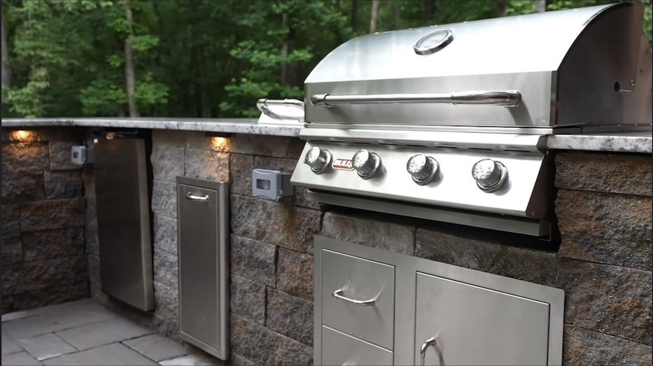 Stainless steel grill in a stone outdoor kitchenette