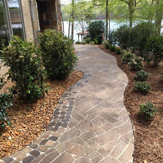 Winding stone walkway leading to a lakefront view.