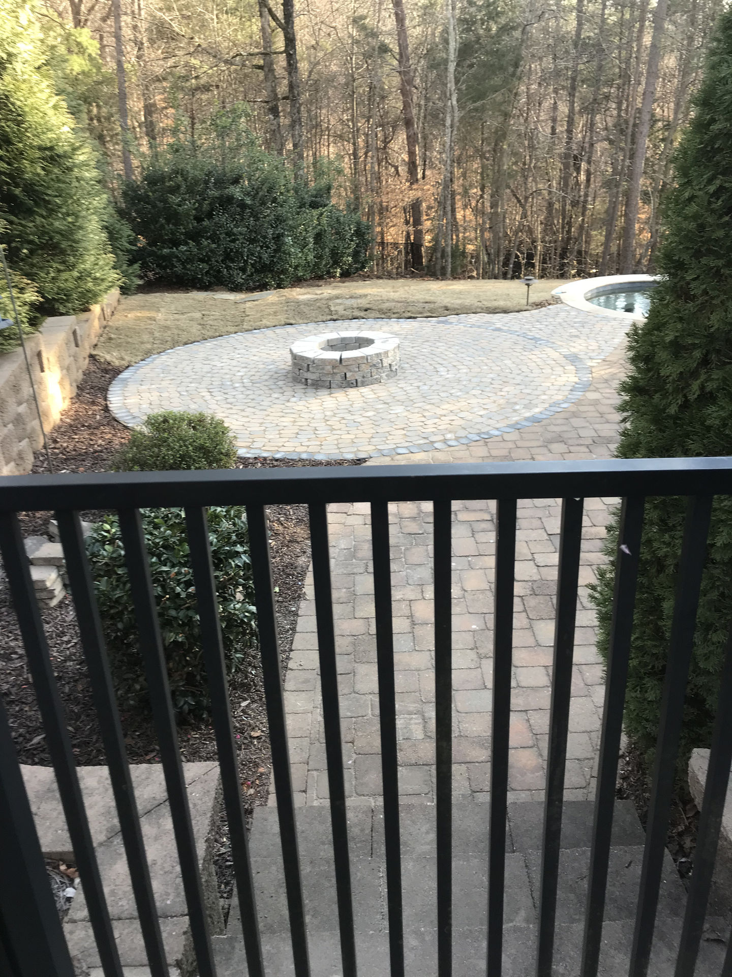 Large stone patio with a circular fire pit area.